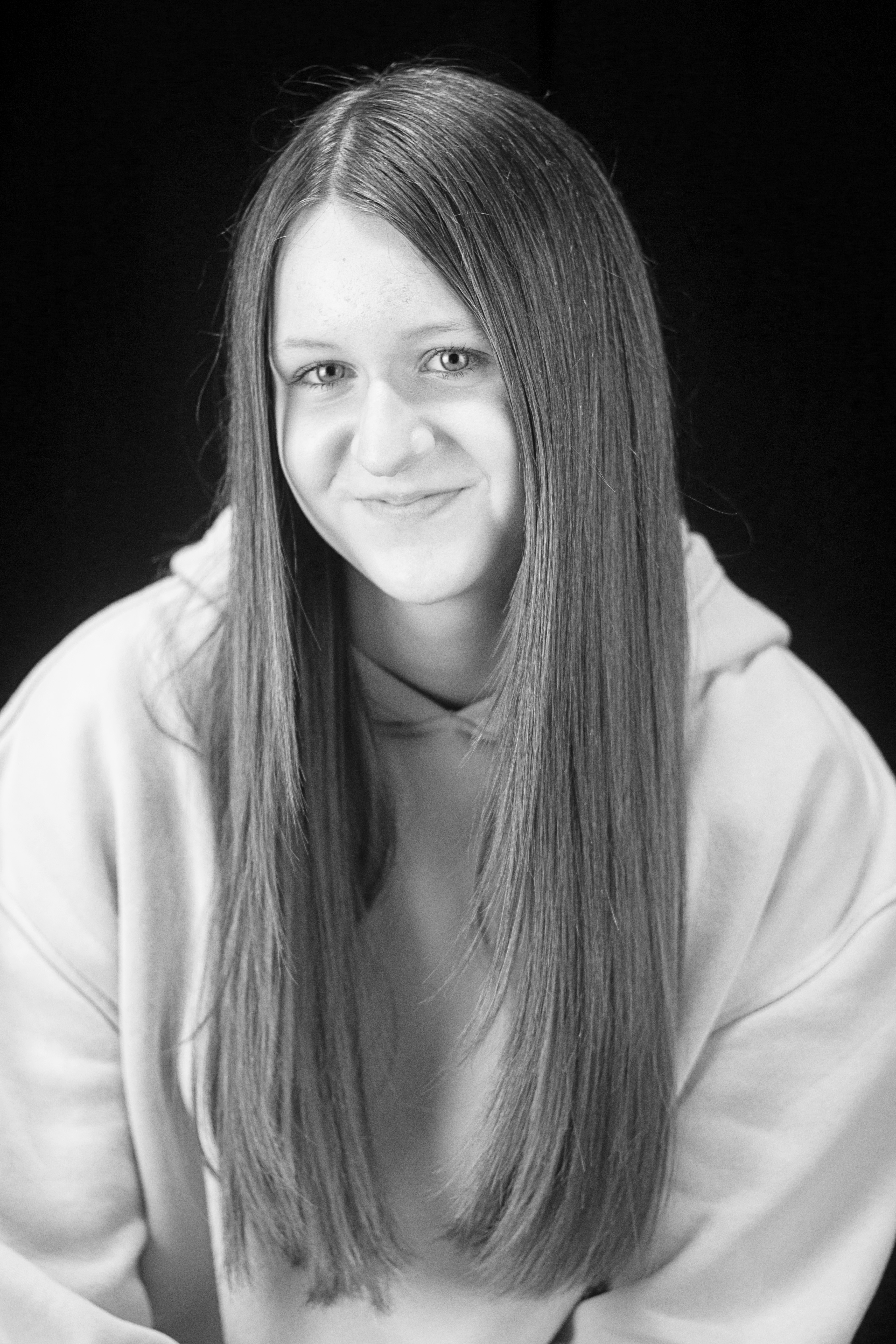 3 female figures stand looking forwards, shielding their eyes from the sun